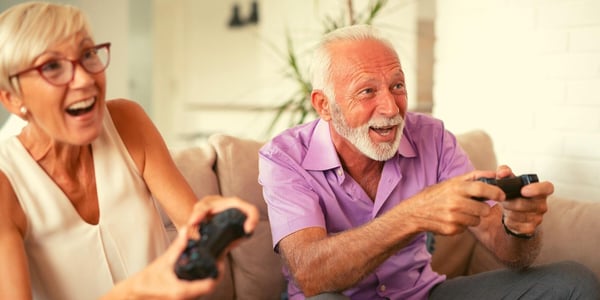 Elderly couple enjoying playing computer games for senior citizens together.
